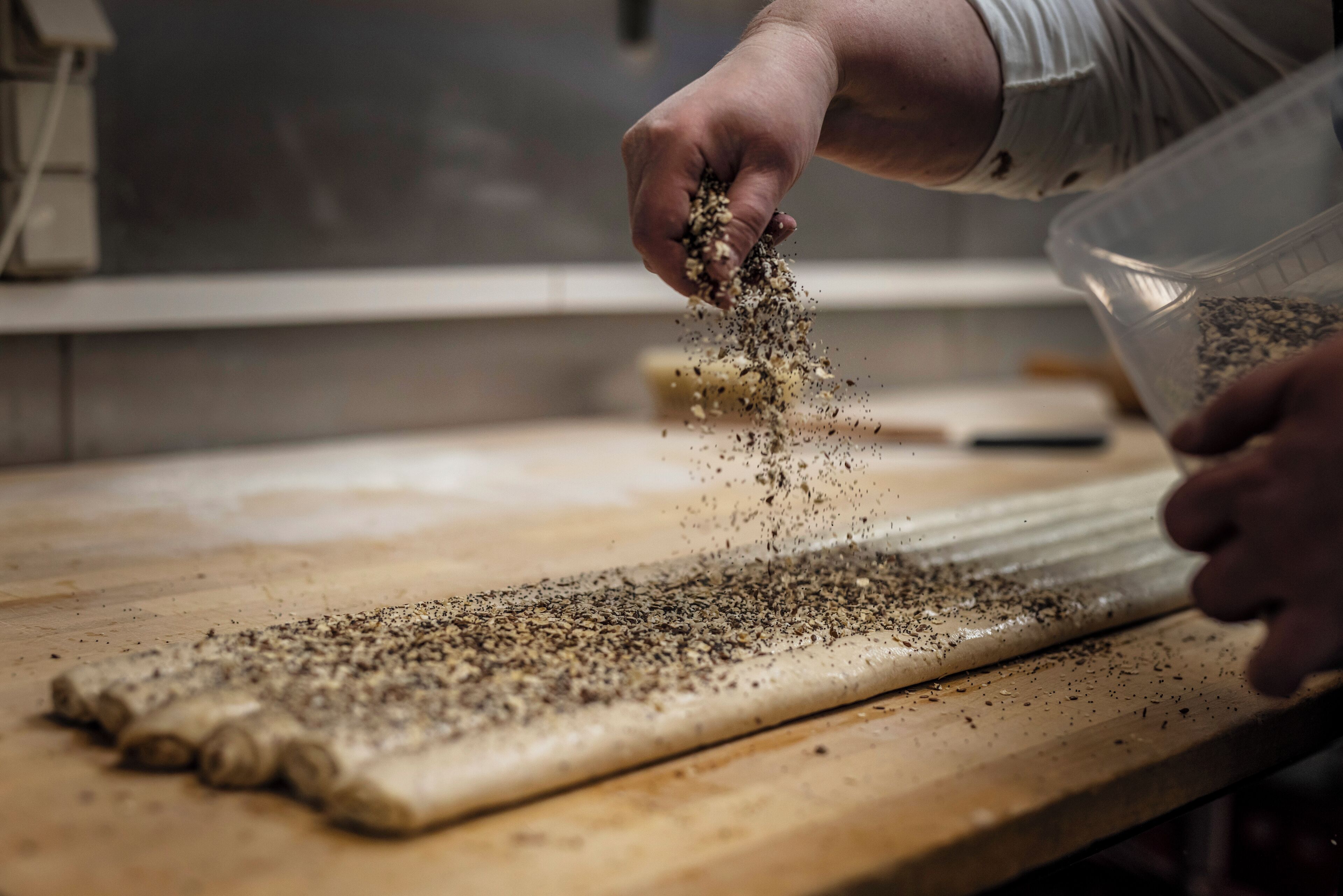 A person sprinkling seasoning on a flat surface.