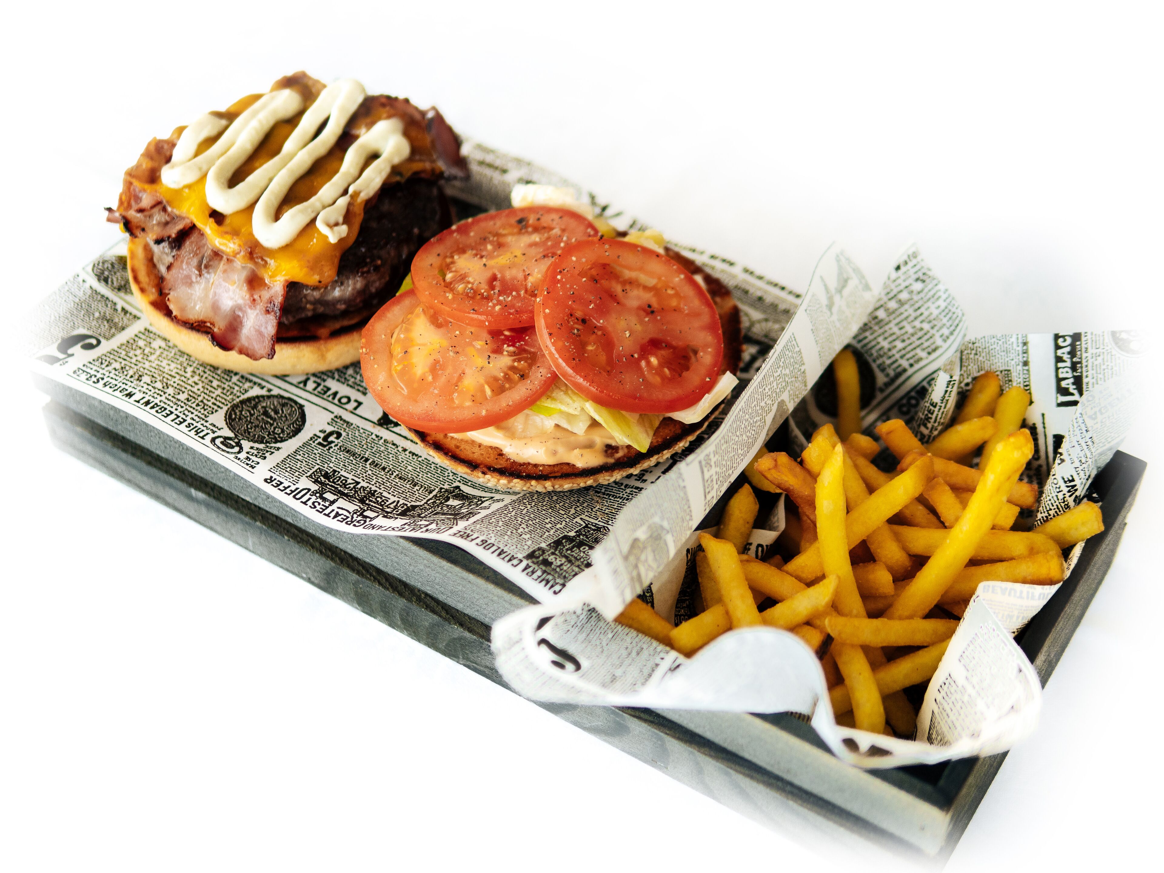 A burger and fries on a newspaper.
