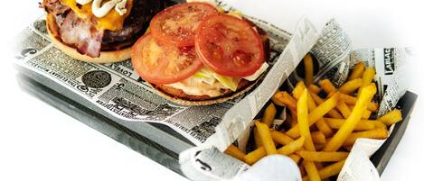 A burger and fries on a newspaper.