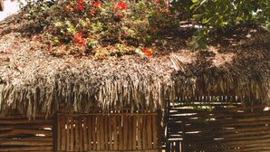 A thatched-roof structure with a wooden slatted entrance, surrounded by a wooden deck. - Pousada Naquela (Jijoca de Jericoacoara)