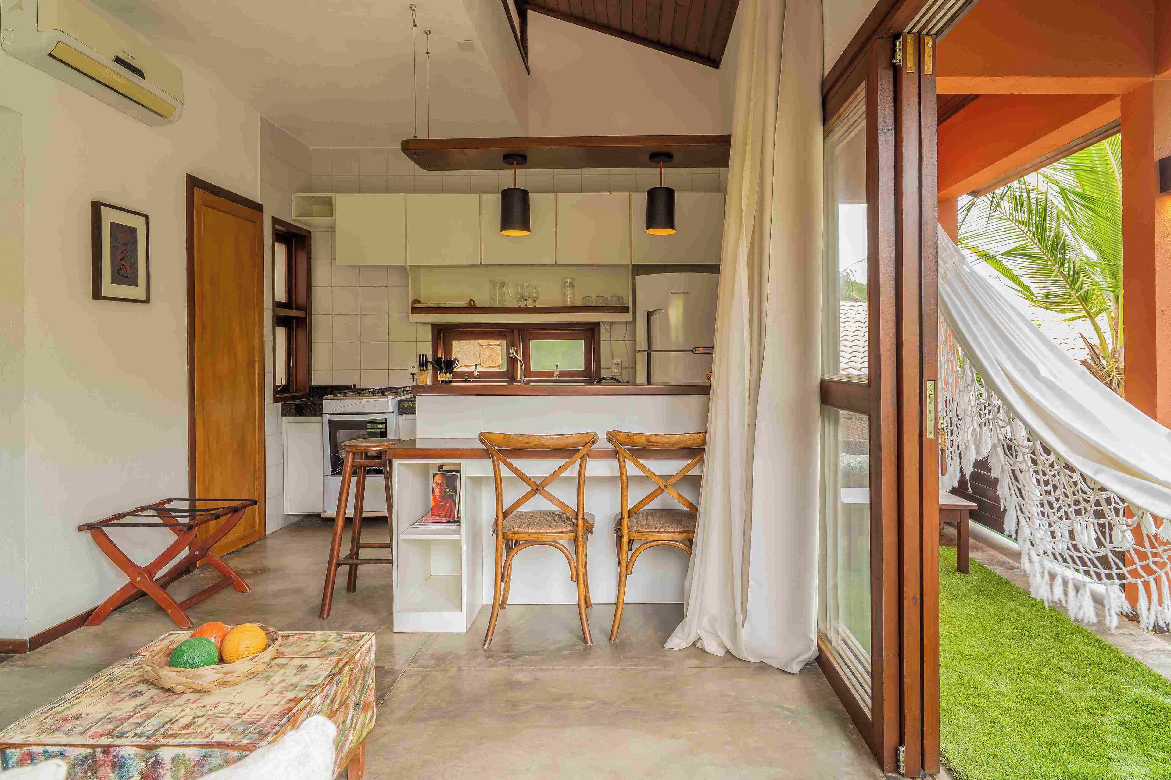 Una cocina moderna con armarios blancos, una isla central e iluminación colgante.