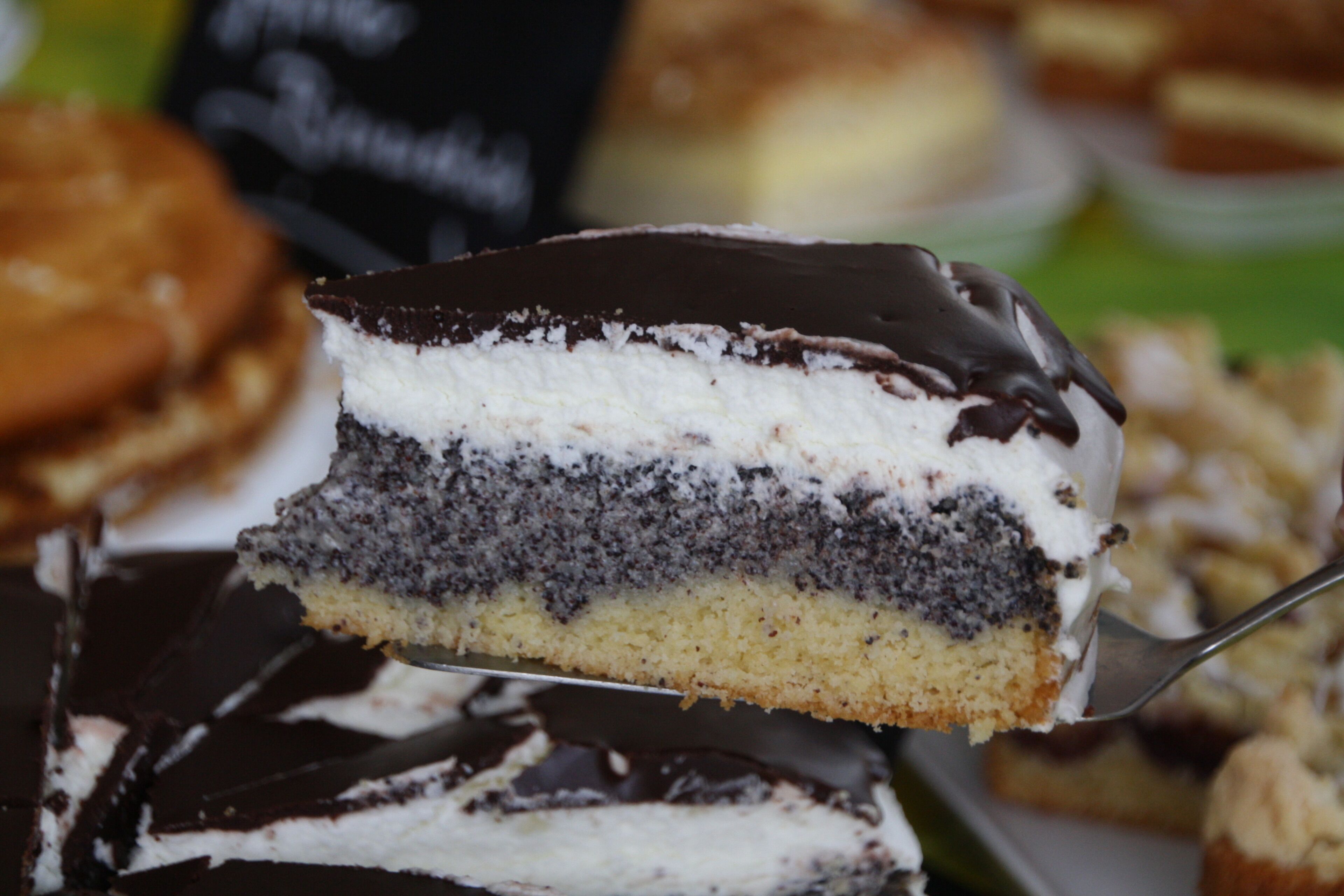 A slice of layered cake with chocolate and white frosting.