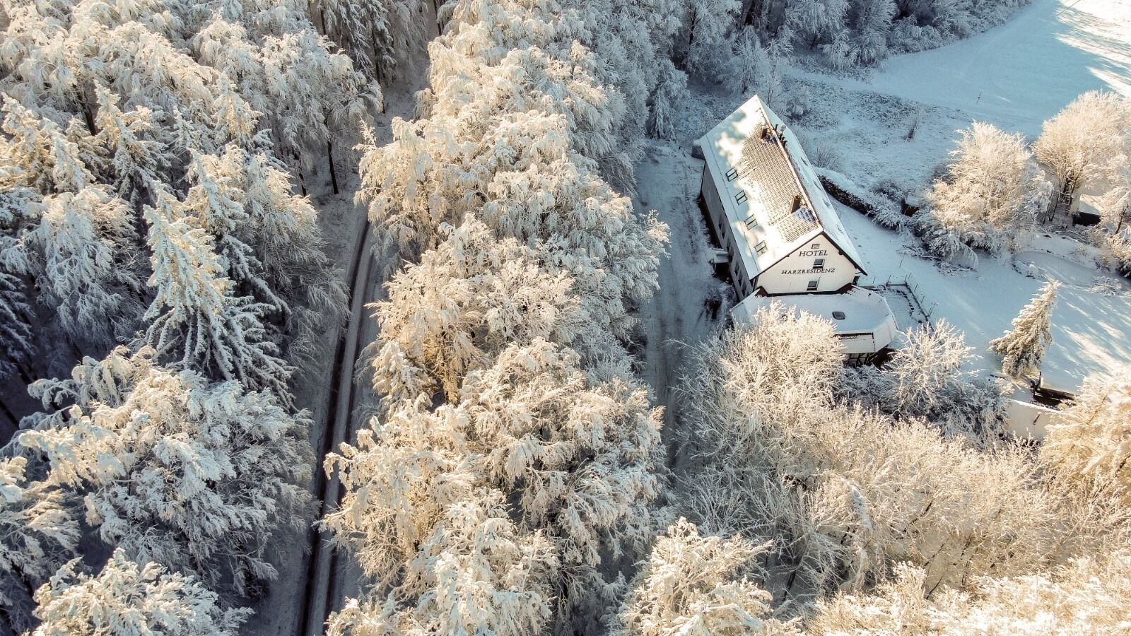 Un hotel cubierto de nieve, con una estructura larga y un estacionamiento.