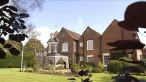 A large, two-story brick house with a well-maintained lawn and a small gazebo. - The Newtown House Hotel (Hayling Island)