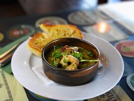 Un tazón de sopa con pan sobre una mesa.