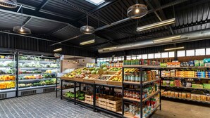 A grocery store with produce, canned goods, and packaged foods on shelves. - Le Petit Village Hotel & Spa (Kampala)