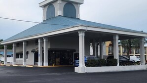 A building with a covered entrance, columns, and a small tower-like structure on the roof. - Quality Inn Perry (Perry)