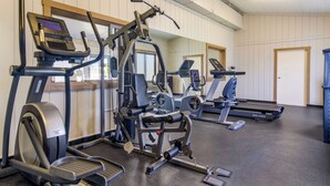 Een sportschool met loopbanden, elliptische trainers en gewichten.