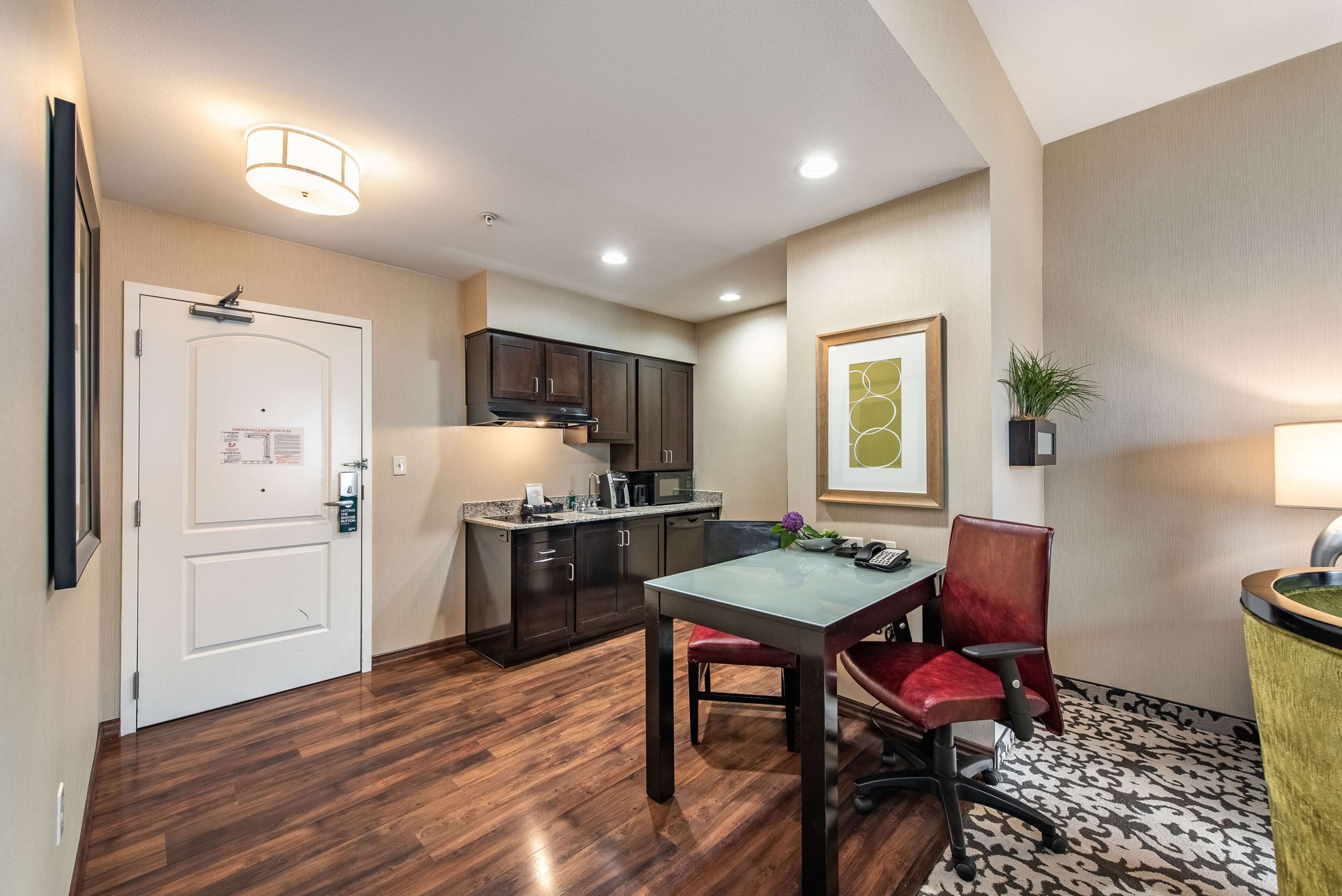 A compact kitchen with dark cabinets, a countertop, and a hanging light fixture.