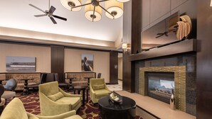 A modern lounge area with comfortable seating, a fireplace, and a ceiling fan. - Homewood Suites by Hilton Oxnard/Camarillo (Oxnard)