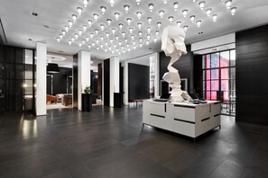 Ein modernes Interieur mit einer zentralen Insel-Schreibtischzeile, Einbauleuchten und großen Fenstern.