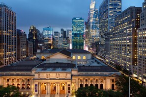 Un paysage urbain avec des immeubles modernes de grande hauteur et un bâtiment classique doté d’une entrée centrale et de colonnes.