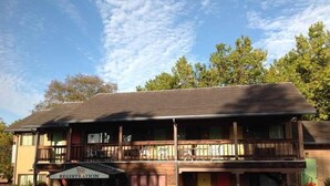 A two-story building with a registration sign, a balcony, and a parking lot. - Humboldt Redwoods Inn (Garberville)