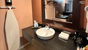 A bathroom with a sink, mirror, and towel rack. - Annie Oakley Motel Oakley (Oakley)