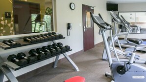 A gym with treadmills, dumbbells, and a red bench. - Sleep Inn & Suites Round Rock - Austin North (Round Rock)