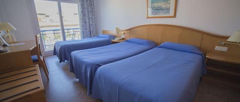 A hotel room with two beds, a desk, a chair, a telephone, and a window with a view.