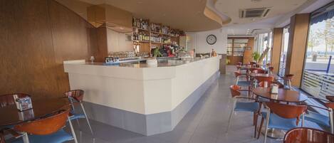 Un espace bar moderne avec un comptoir, des étagères remplies de bouteilles et une horloge au mur.