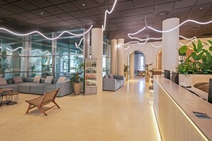 Un hall d’entrée moderne doté d’un comptoir de réception, d’espaces d’attente et de grandes fenêtres.