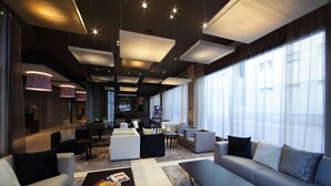 Un hall d’hôtel moderne avec des canapés, une table basse et un téléviseur.