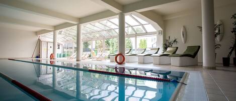 Una piscina cubierta, tumbonas