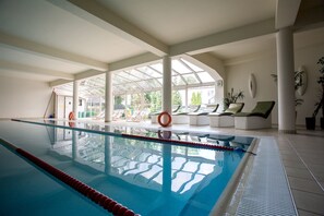 Una piscina cubierta, tumbonas