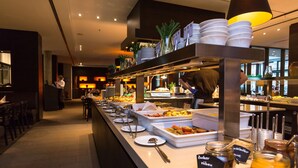 A buffet setup with various food items and serving utensils.