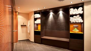 Bathroom features a large mirror, bench, and shelves with neatly folded towels.