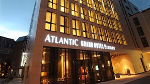The exterior of the Atlantic Grand Hotel Bremen with a modern facade, large windows, and a prominent entrance.
