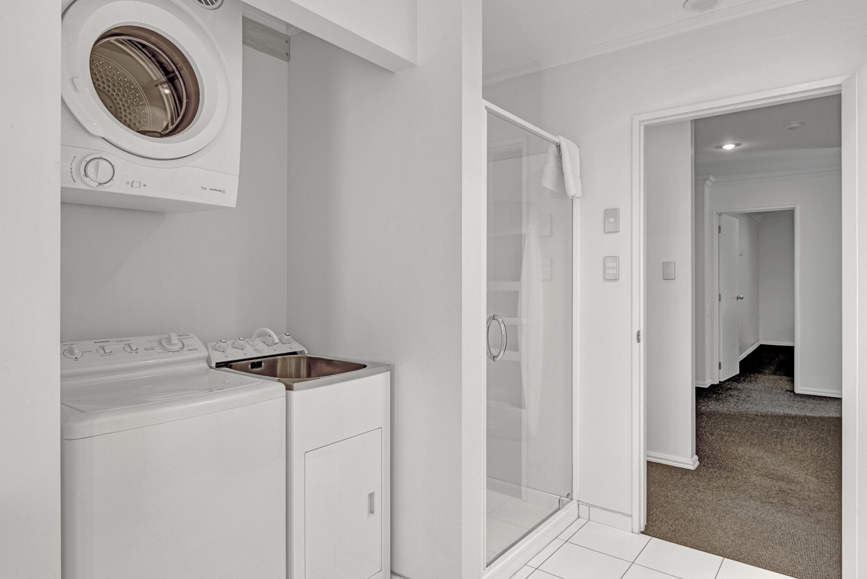 A laundry area with a washing machine, dryer, and sink.