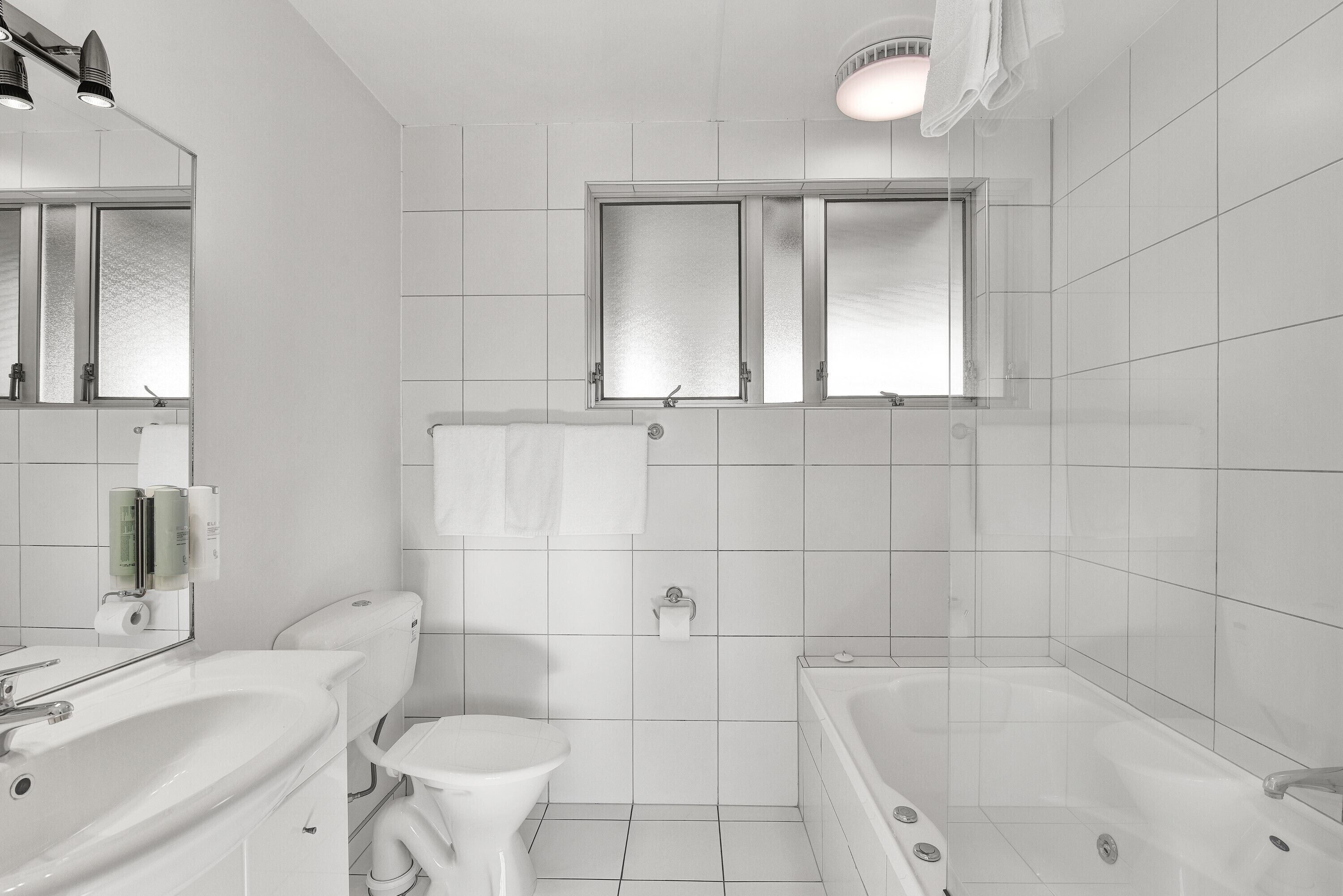 Un baño moderno con inodoro, lavamanos y bañera.