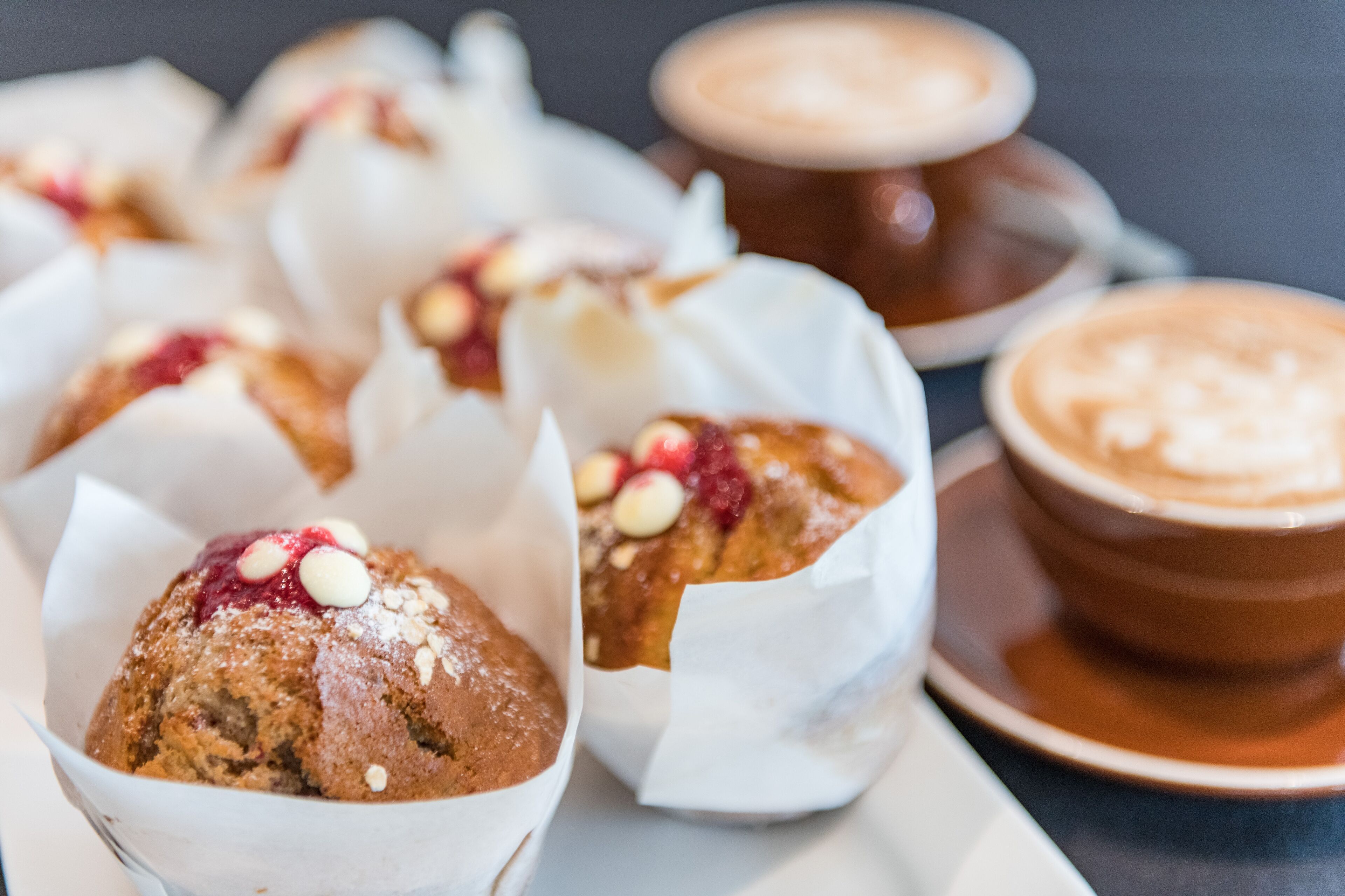Un vassoio con muffin e guarnizioni, e una tazza di caffè.