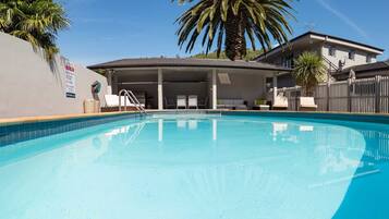 Een seizoensgebonden buitenzwembad, een verwarmd zwembad en ligstoelen