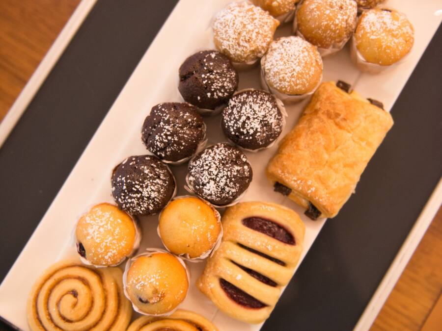 A tray of assorted pastries including chocolate balls, lemon tarts, and cinnamon rolls.
