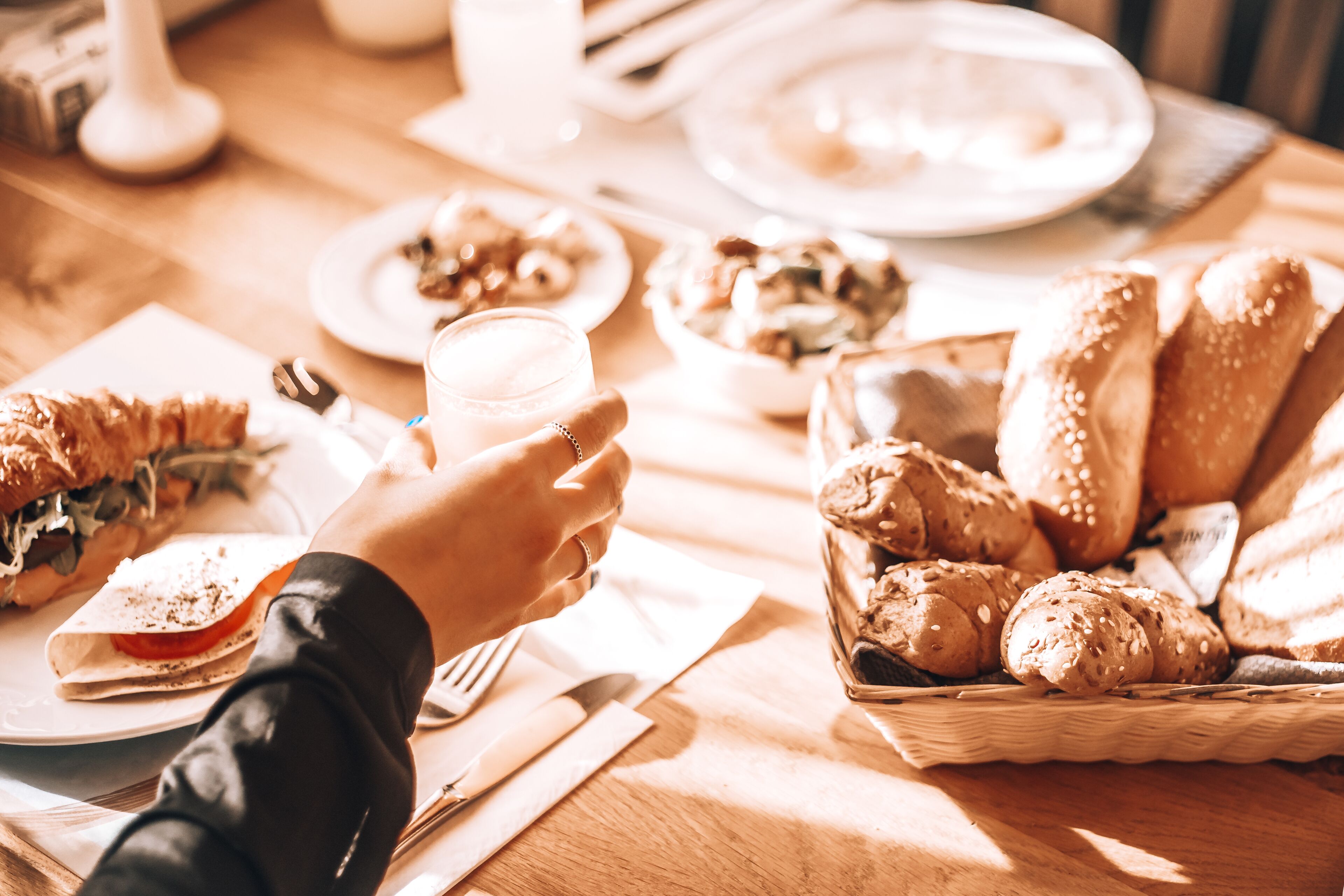 Une table à manger avec divers aliments, notamment du pain, un sandwich et un verre d’eau.