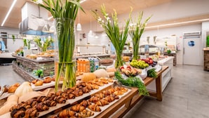 Un bufé con diversos alimentos y flores frescas.