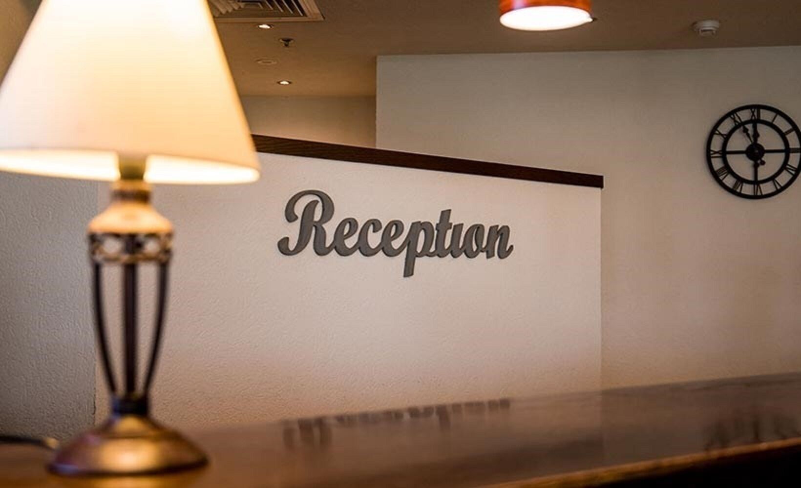 A reception area with a sign that reads "Reception" and a wall clock.