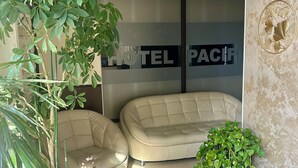A hotel lobby with a sofa, a small table, a potted plant, and a sign reading 'HOTEL PACE'. - Hotel Pacific Timisoara (Timisoara)