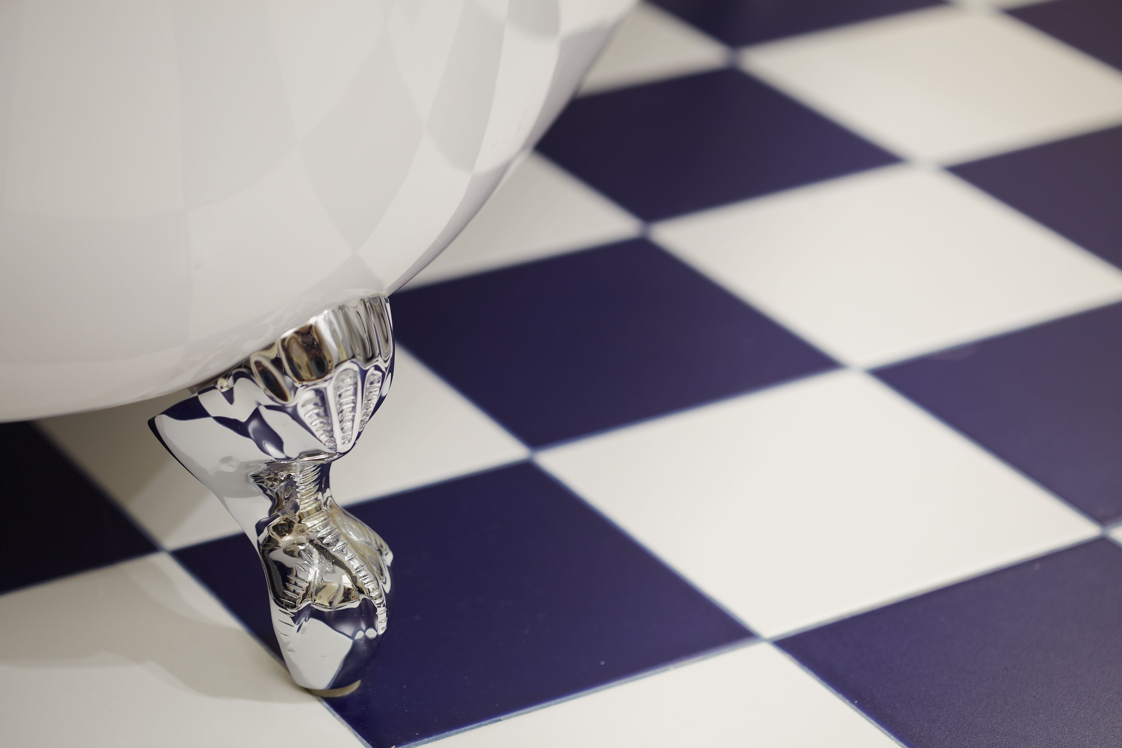 Un baño con un lavamanos blanco y un piso con estampado de cuadros.