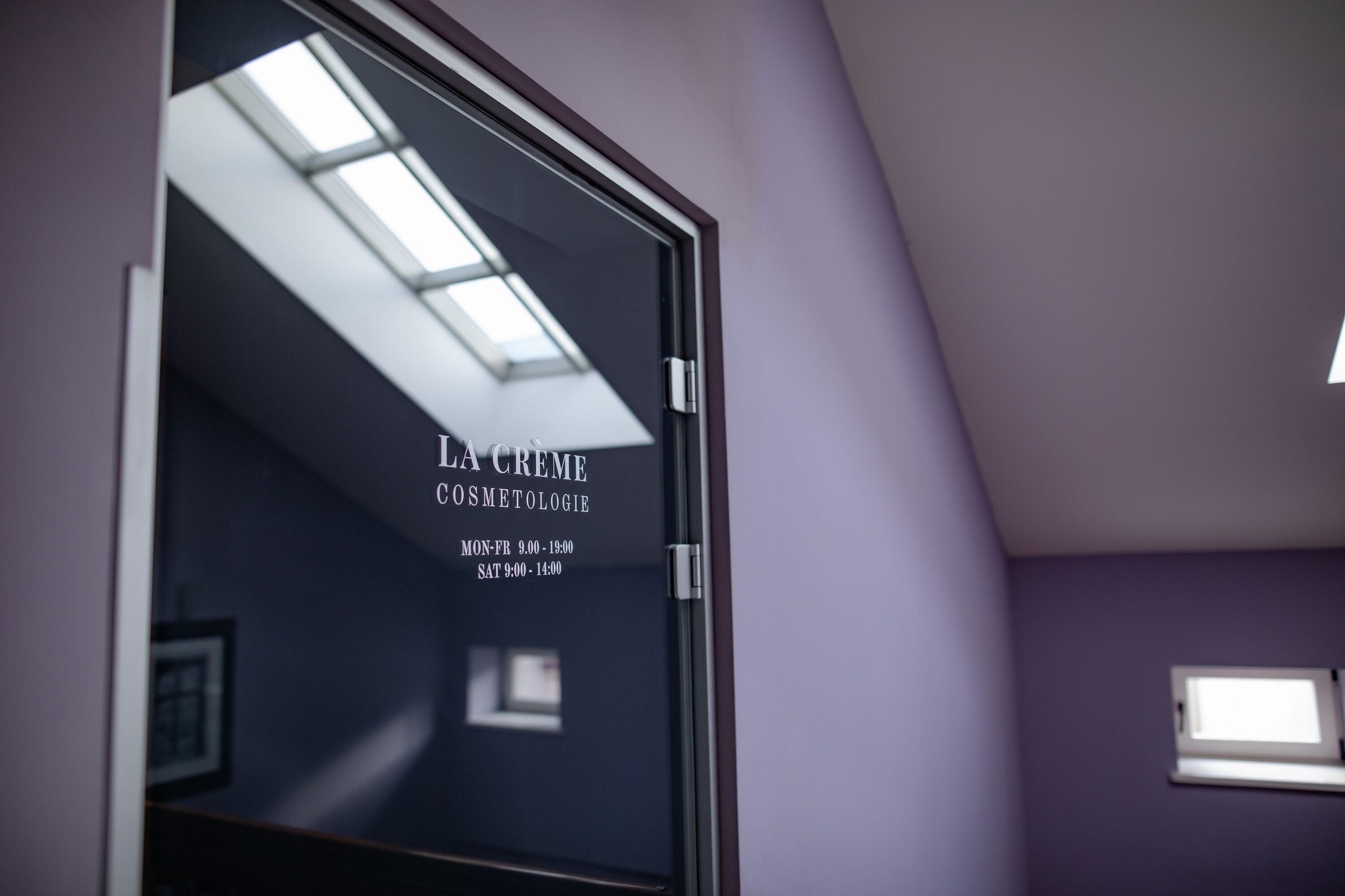 A window with the text "LA CREME COSMETOLOGIE" and operating hours.