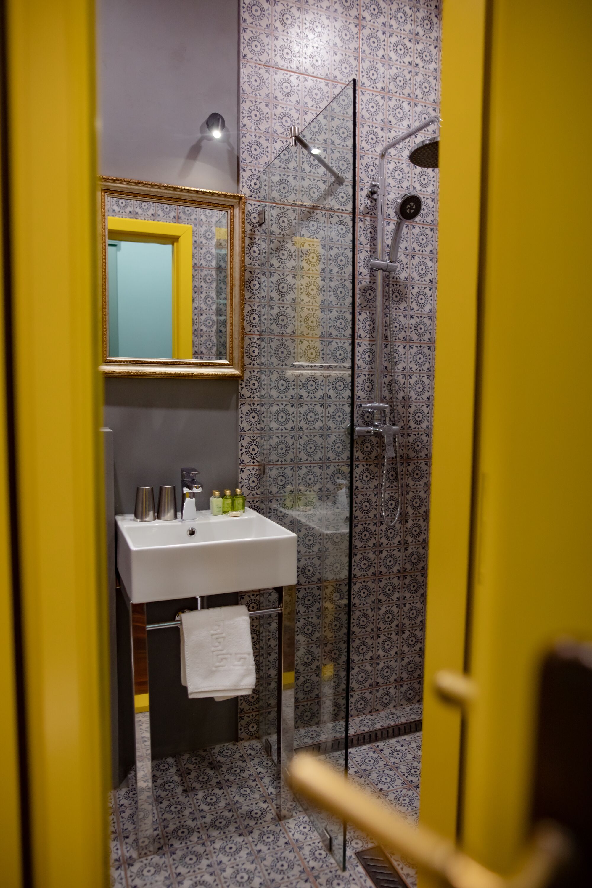 Ein Badezimmer mit einem weißen Waschbecken, Spiegel und Dusche.