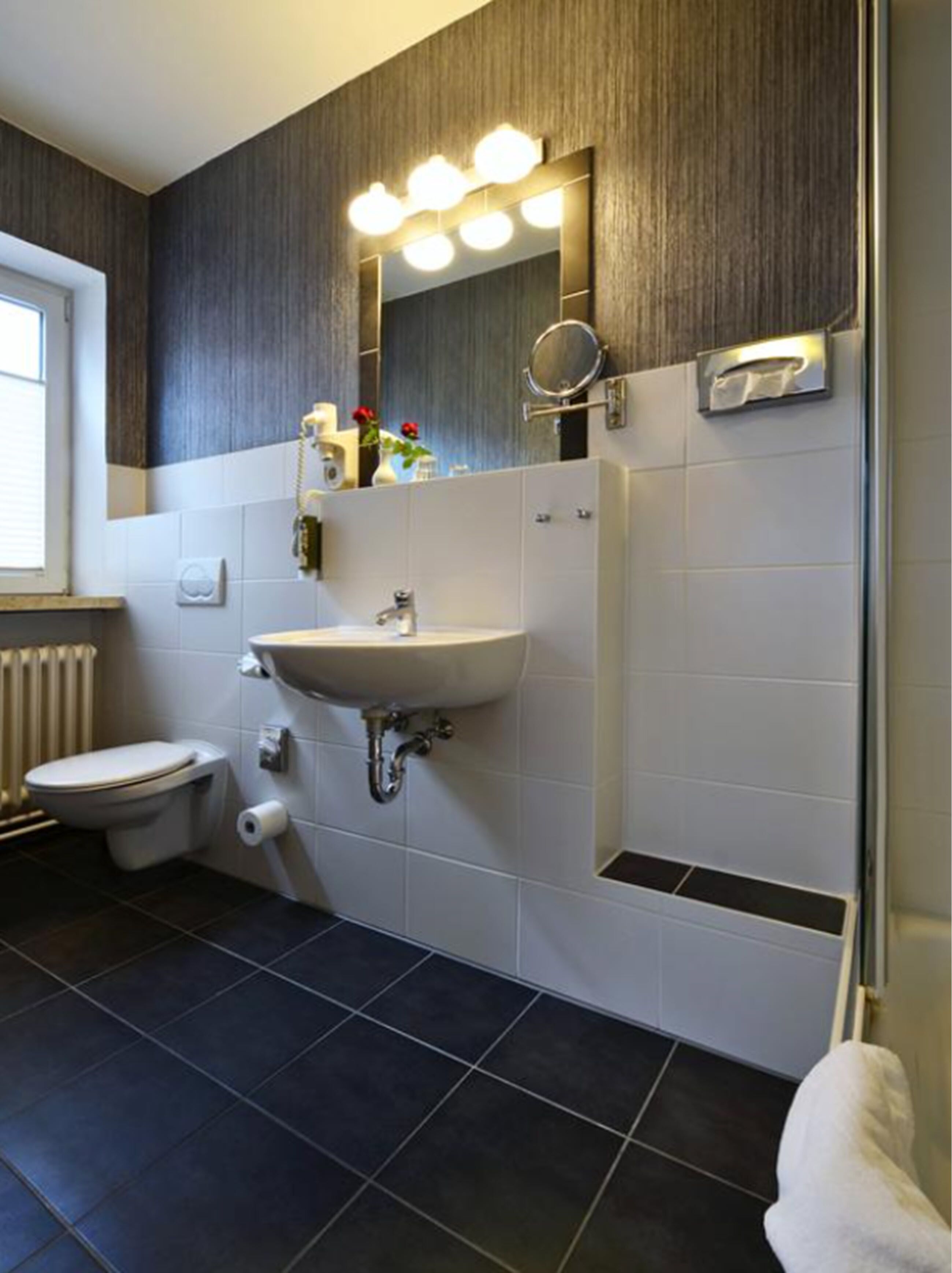 Ein modernes Badezimmer mit Waschbecken, Toilette und Duschbereich.