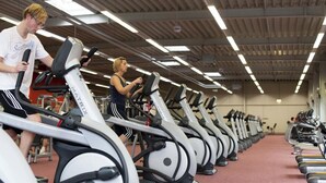 A gym with multiple treadmills lined up in rows. - Comfort Hotel Tom Kyle (Kiel)