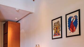 Una habitación moderna con un escritorio de madera, una silla azul y dos obras de arte enmarcadas en la pared.