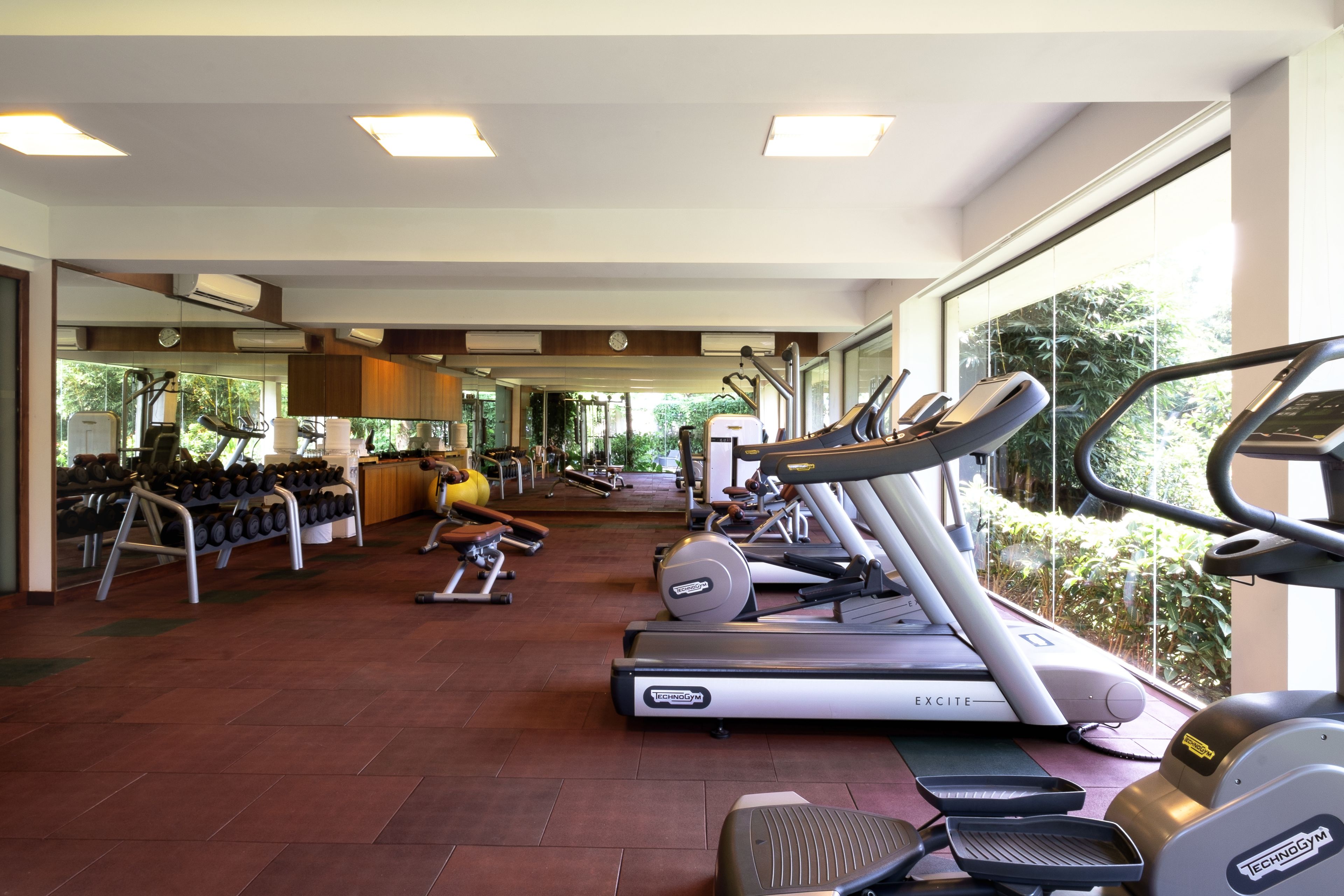 Un gimnasio con cintas de correr, mancuernas y equipamiento de ejercicio.