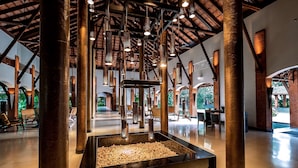 A spacious lobby with high ceilings, large pillars, and a central water feature. - Alila Diwa Goa - A Hyatt Brand (Majorda)