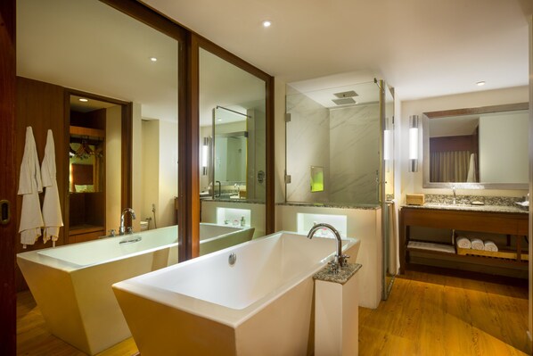 A modern bathroom with a large freestanding bathtub, a glass-enclosed shower, and a vanity with a mirror.