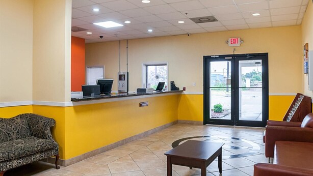 A reception area with a counter, computers, a sofa, and a coffee table.