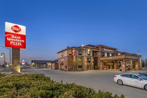 A Best Western Plus hotel with a modern brick facade, multiple entry points, and a parking lot with cars. - Best Western Plus Grand Island Inn & Suites (Grand Island)