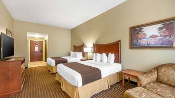 A hotel room with two beds, a TV, a desk, and a painting on the wall.