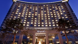 A high-rise hotel with a curved facade, multiple floors, and a well-lit entrance. - Kempinski Hotel Yinchuan (Yinchuan)